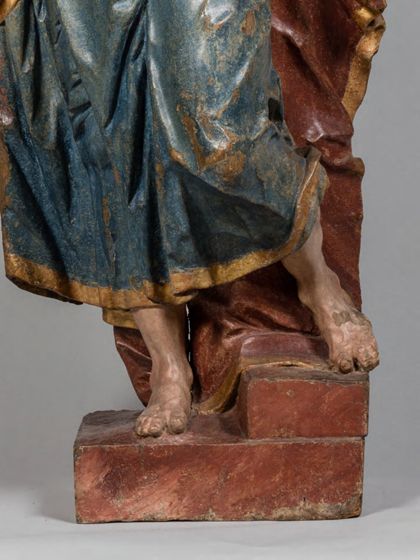 Stehende Holzskulptur des Apostels Judas Thaddäus in theatralisch verdrehter Körperhaltung und ebenso expressiver Drapierung des stoffreichen Gewands, detail der unteren Partie.