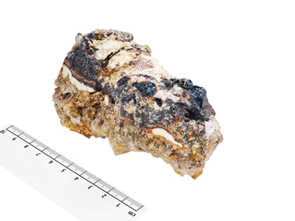 Großstufe mit schwarzem Limonit (derb und als Glaskopf) und hellem Fluorit in zersetztem Ganggestein.