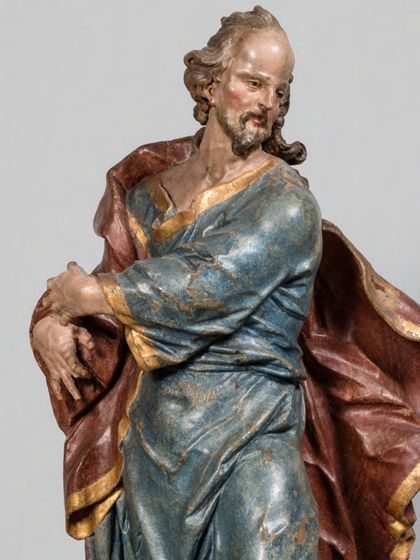 Stehende Holzskulptur des Apostels Judas Thaddäus in theatralisch verdrehter Körperhaltung und ebenso expressiver Drapierung des stoffreichen Gewands, Detail des Oberkörpers.