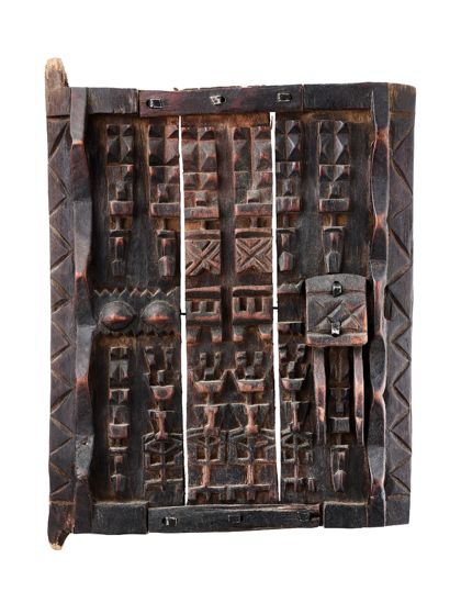 Speichertür aus Holz, mit 12 anthropomorphen Figuren beschnitzt.