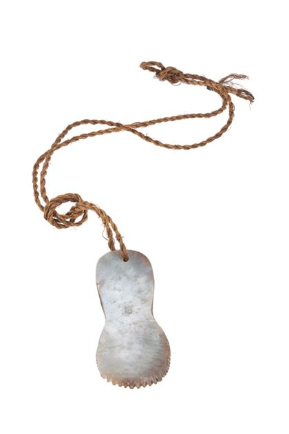 Sohlenförmiges Gerät aus Perlmutt, mit unterem gezacktem Rand.