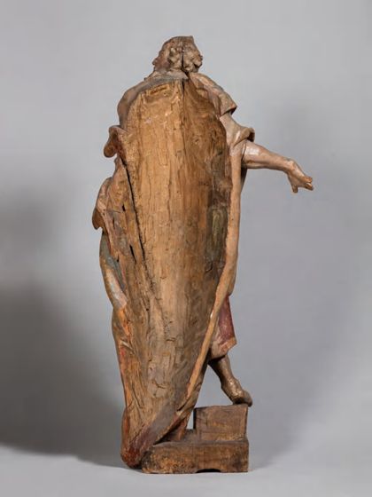 Stehende Holzskulptur des Apostels Simon Zelotes in theatralisch verdrehter Körperhaltung und ebenso expressiver Drapierung des stoffreichen Gewands, Ansicht der ausgehöhlten Rückseite.