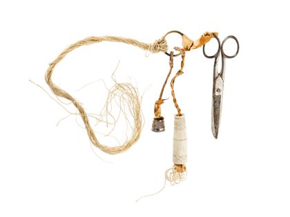 An einem Messingring mittels Lederschlaufen befestigte Nähutensilien - Schere, Fingerhut, Garnbündel und Nadelbehälter.